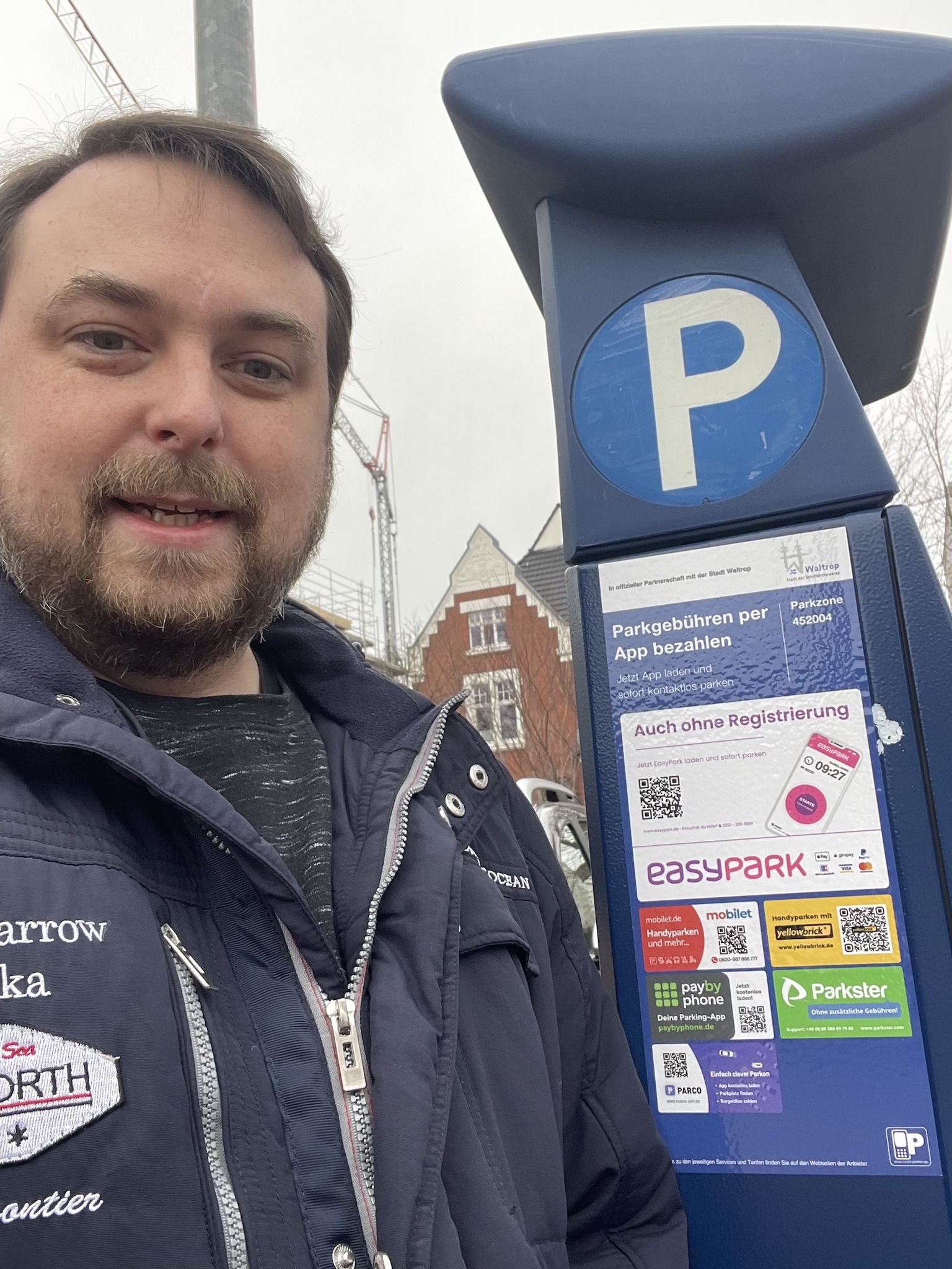 Das Bild zeigt Daniel Toschke vor einem Parkautomat